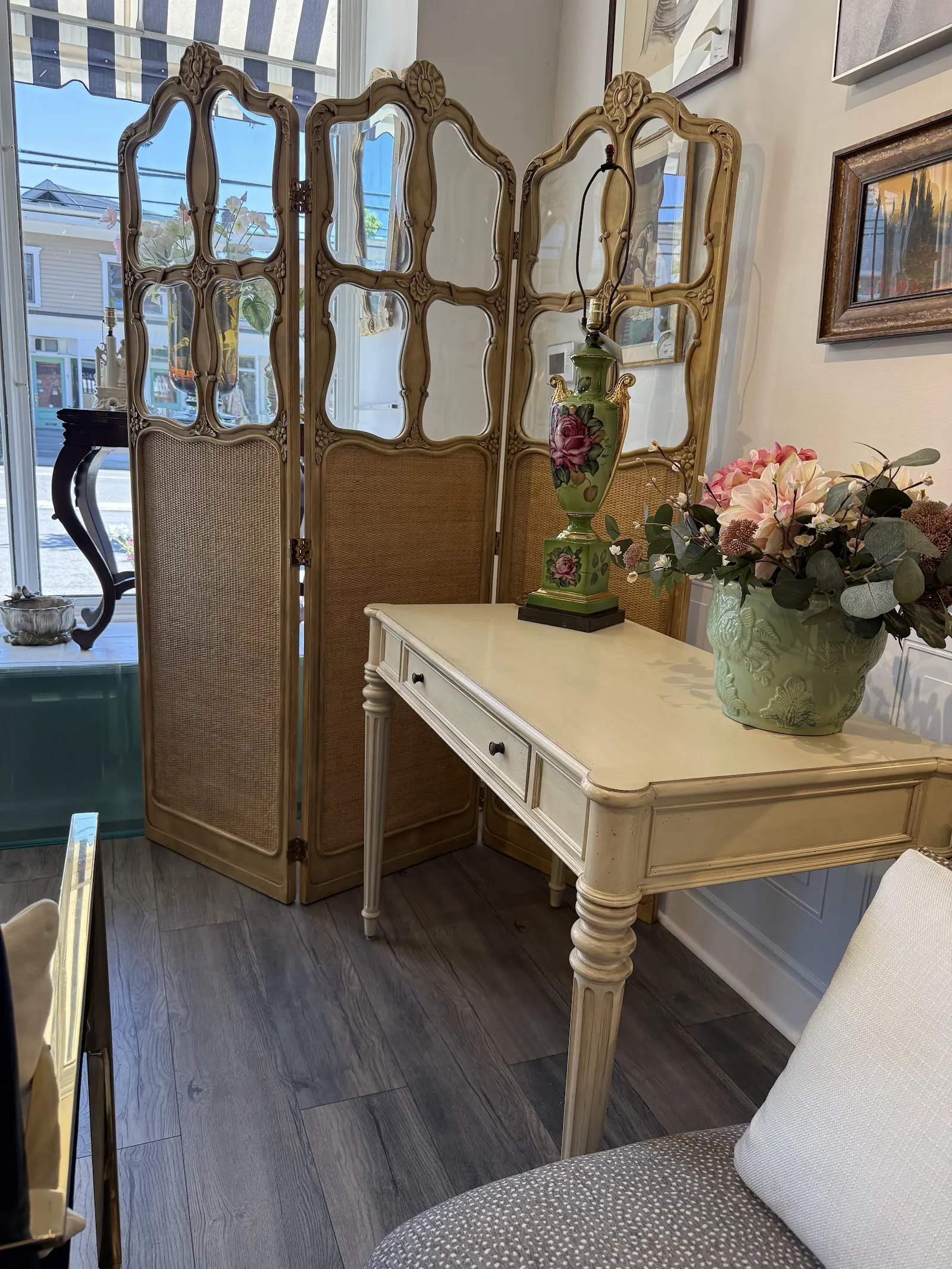 Folding screen room divider beside a vanity desk